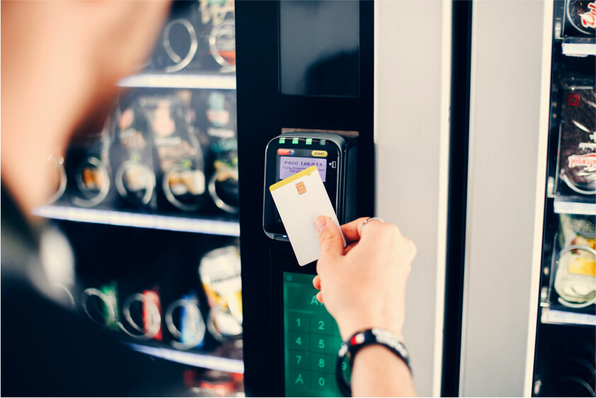Someone paying at a vending machine with a debit card