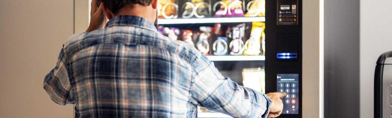 A man selects from a fully managed vending machine with a keypad