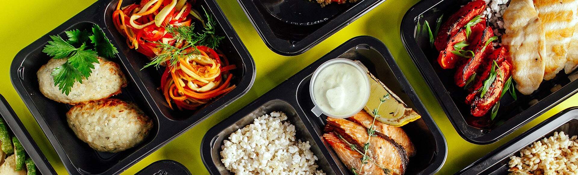 A healthy meal selection with chicken, rice, fish and vegetables office lunch