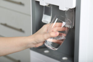 Woman,Filling,Glass,With,Water,Cooler,,Closeup.,Refreshing,Drink