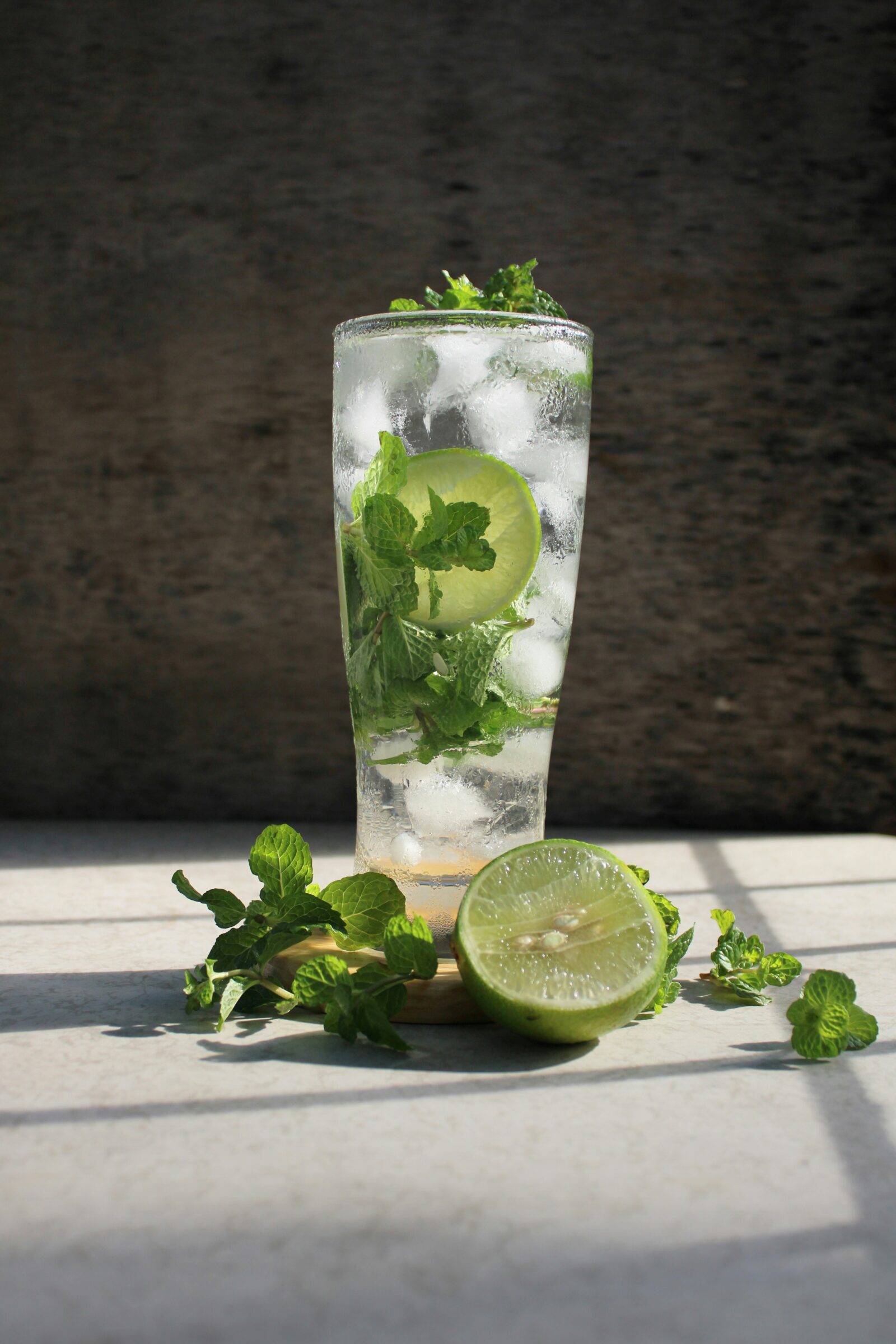 A tall glass of water with mint and lime