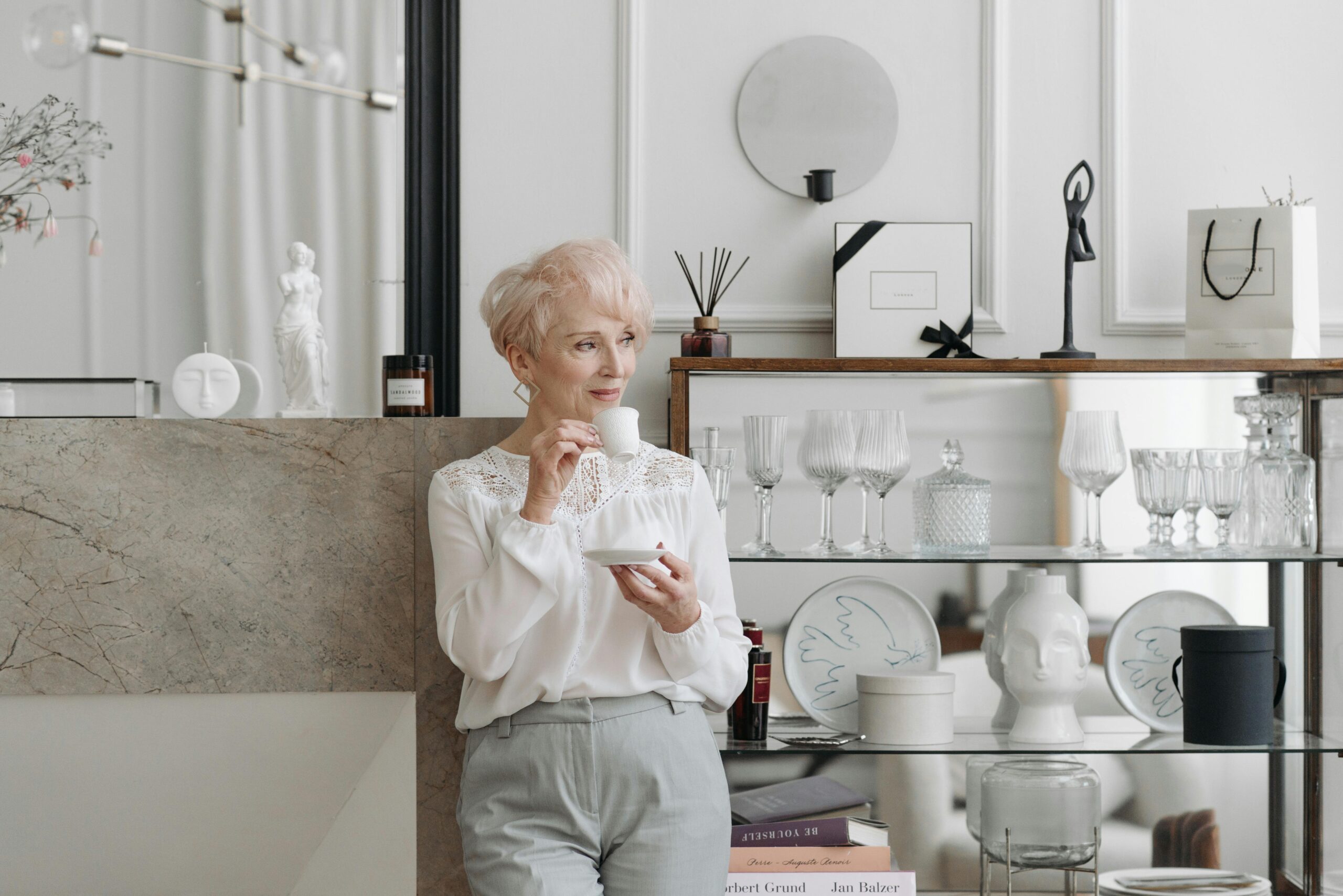 How tea is enjoyed around the world: an elderly woman dressed stylishly drinks tea in a modern kitchen