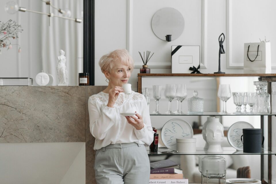 How tea is enjoyed around the world: an elderly woman dressed stylishly drinks tea in a modern kitchen