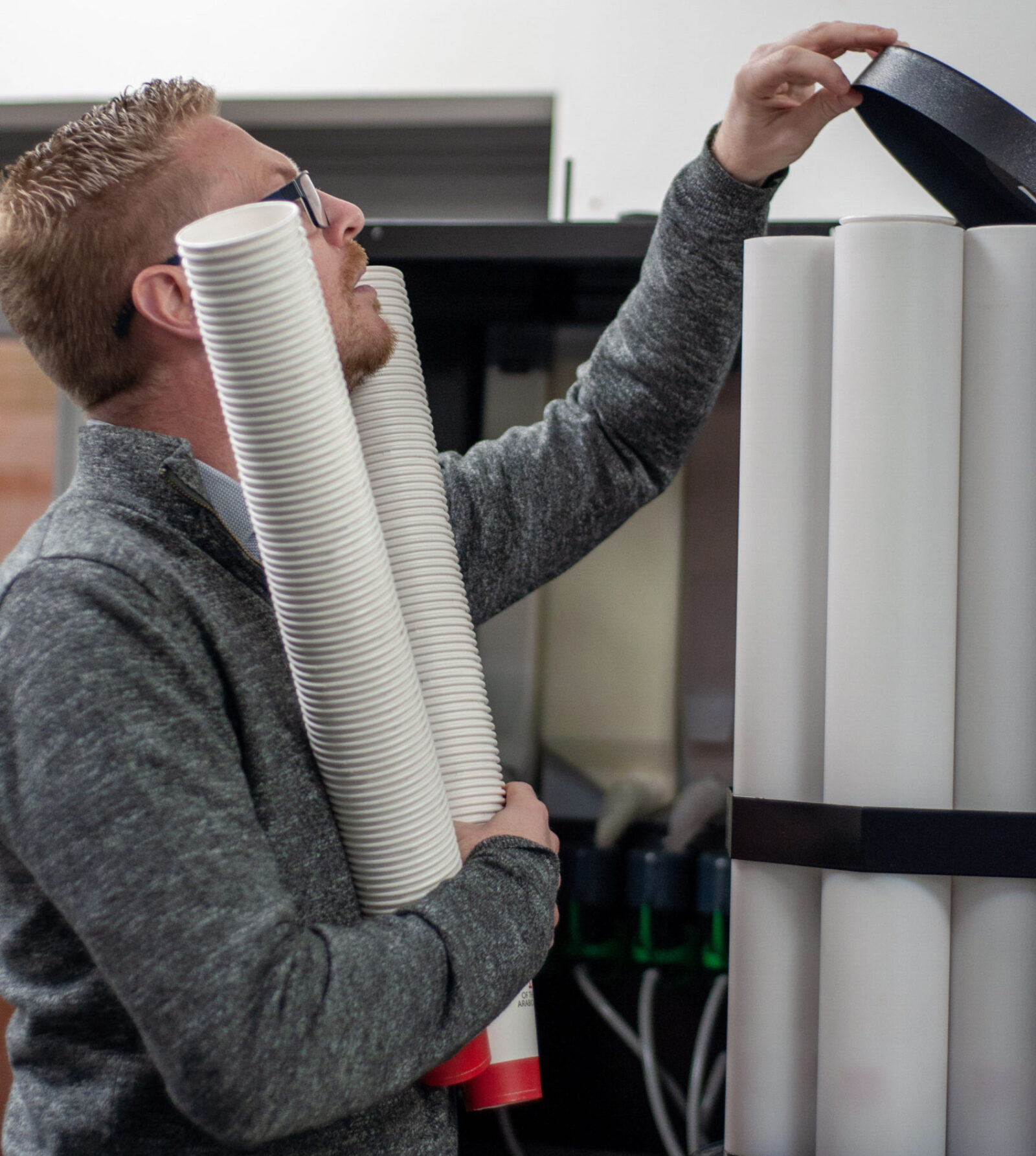 Person loading cups into an illy floor-standing coffee machine