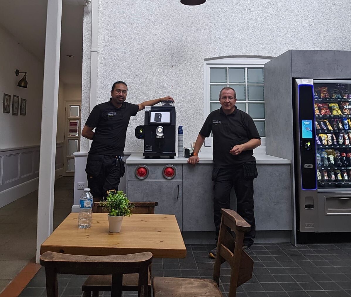 engineers installing a commercial coffee machine in a workplace